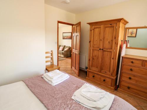 - une chambre avec un lit et une commode en bois dans l'établissement Kingfisher Cottage, à North Molton