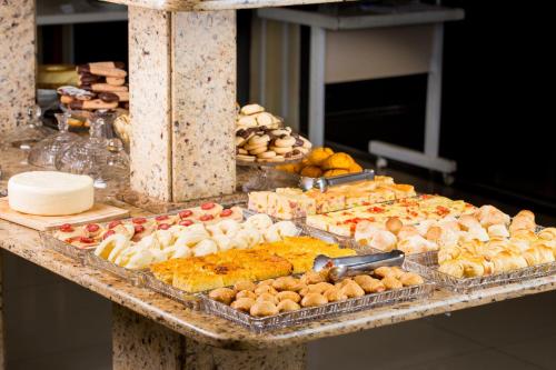 a buffet with many different types of food on a table at WR Confort Hotel Campo Grande in Campo Grande