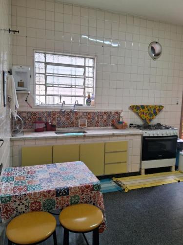 a kitchen with a table and two stools in it at Casa Térrea SP Expo e C Paralimpico in São Paulo