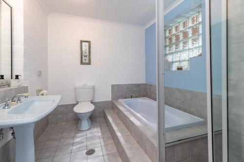 ein Badezimmer mit einer Badewanne, einem WC und einem Waschbecken in der Unterkunft Blue Pacific in Blueys Beach