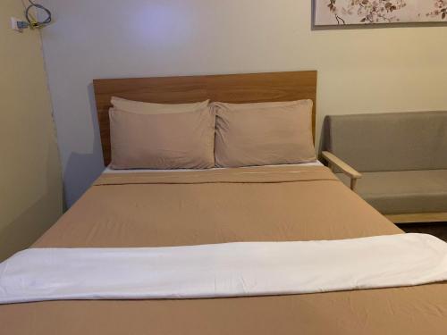 uma cama com duas almofadas e um sofá num quarto em Avida Tower Furnished Contemporary Studio Unit em Davao