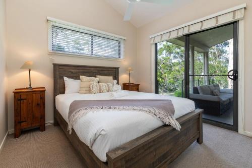 a bedroom with a large bed and a window at A Yarraangunthi in Smiths Lake