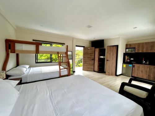 a bedroom with two bunk beds and a kitchen at OCEAN DRIVE LODGE in Montañita