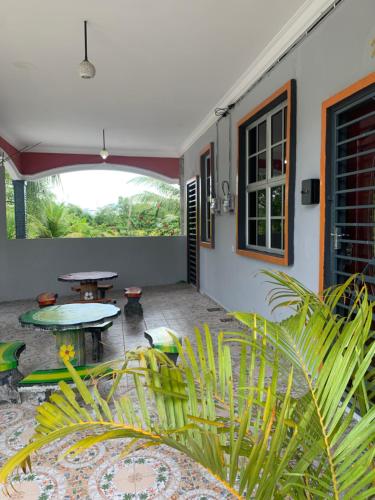 a patio with a table and some plants at Rerama Homestay Langkawi 5 minutes driving to Chenang Beach, kitchen, Wifi, parking, village vibes in Pantai Cenang