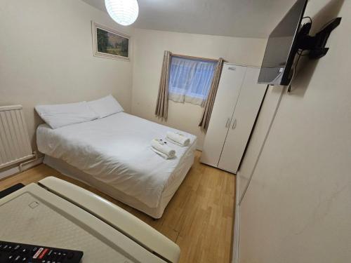 a small room with a bed and a refrigerator at Bruce Rooms in London