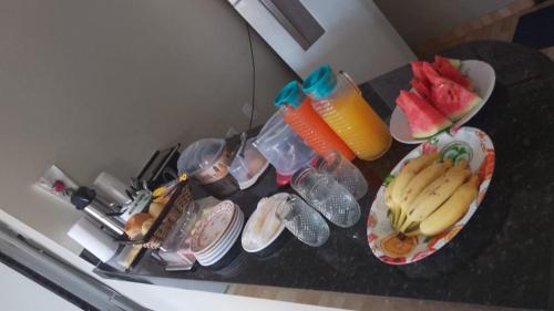 a counter with plates of fruit and drinks on it at HOTEL NOVAES in Castanhal