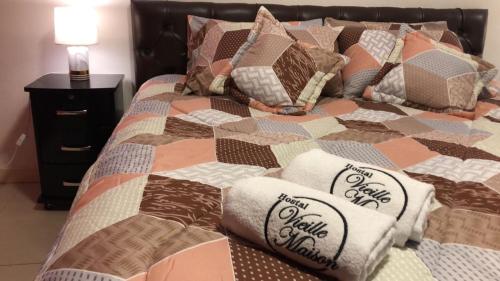 a bed with a quilt and pillows on it at HOTEL VIEILLE MAISON in Quito
