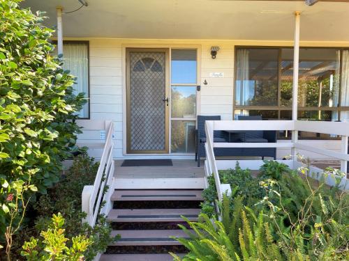 un porche delantero de una casa con escaleras y una puerta en Parnella Cottage - Pet friendly, en St Helens