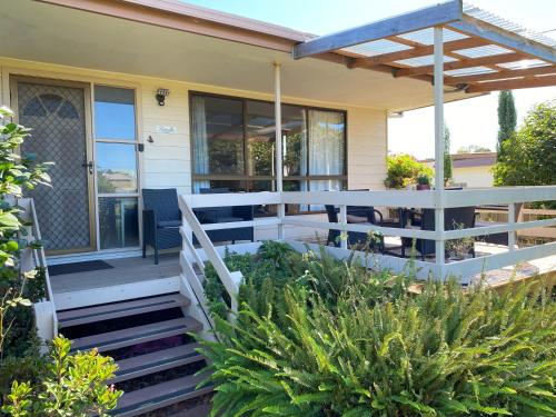 una casa con una recinzione bianca e un portico di Parnella Cottage - Pet friendly a St Helens