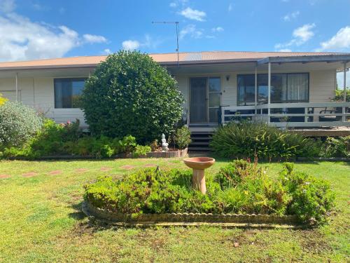 a house with a bird bath in a yard at Parnella Cottage - Pet friendly in St Helens