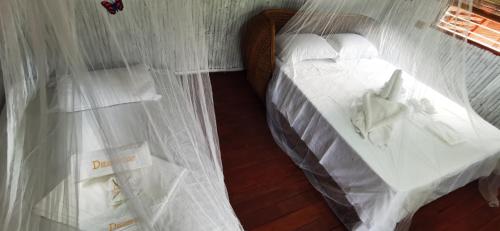 a bedroom with a bed with white comforter at Dreamer Resort in San Vicente