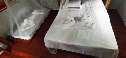 a bed with white sheets and towels on it at Dreamer Resort in San Vicente