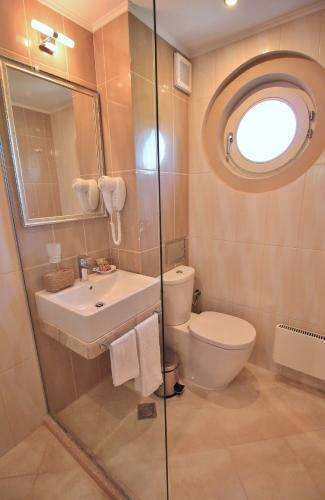a bathroom with a toilet and a sink and a mirror at Residence House Ruse in Ruse