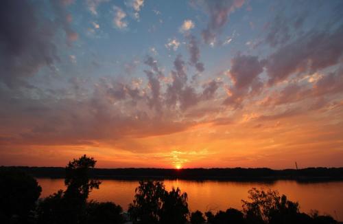 a sunset over a lake with the sun setting at Residence House Ruse in Ruse