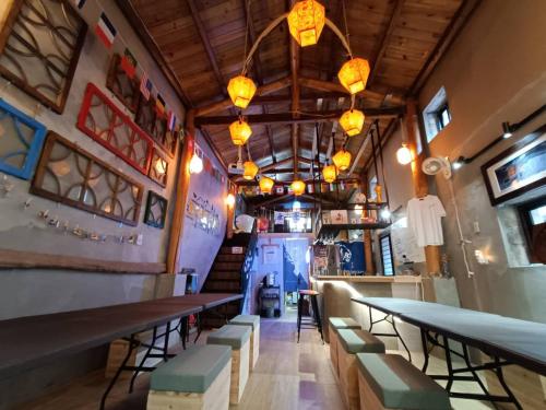 a restaurant with tables and chairs in a room at 馬祖津沙背包客棧-Jinsha backpacker inn in Nangan