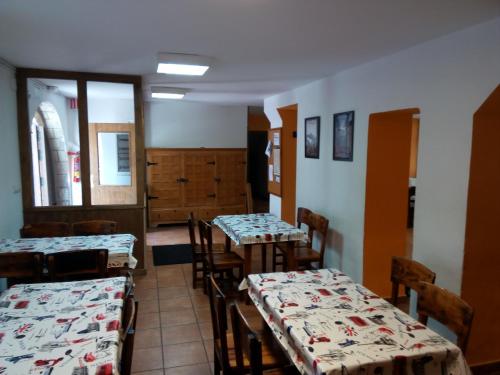 a dining room with tables and chairs and a room with windows at Albergue de Canfranc Estación in Canfranc-Estación
