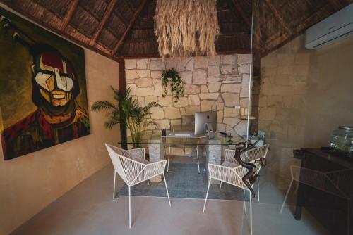 Cette chambre comprend une table avec des chaises et un ordinateur portable. dans l'établissement Nikau Hotel El Cuyo - Adults Only, à El Cuyo