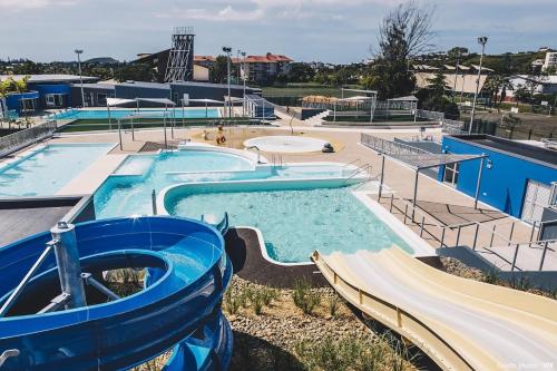 a large swimming pool with a water slide at La Perle Azurée in Noumea
