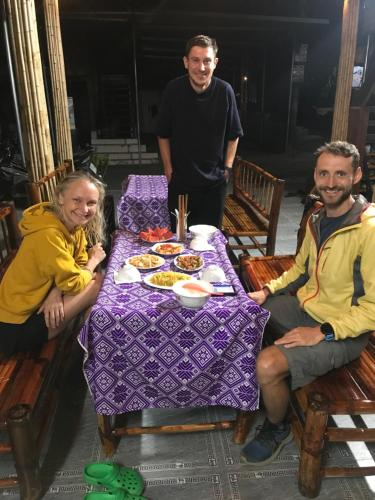 a group of people sitting around a table with food at Mai chau Horizon Homestay in Mai Chau