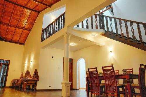 ein Esszimmer mit einem Tisch, Stühlen und einer Treppe in der Unterkunft Elegant Riverside Villa in Dematapelessa