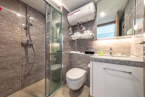 een badkamer met een douche, een toilet en een wastafel bij Plaza Residence Apartment - Shenzhen Futian Convention & Exhibition Center in Shenzhen
