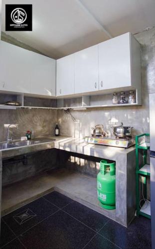 a kitchen with white cabinets and a green trash can at Deleted 6 in Calayo
