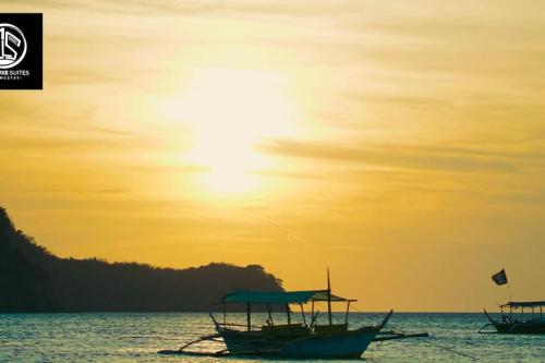 two boats sitting in the water at sunset at Deleted 6 in Calayo