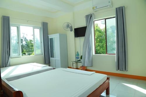 duas camas num quarto com duas janelas em View Nhat Le Beach Hotel em Dong Hoi