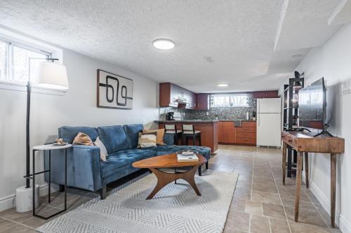a living room with a blue couch and a table at COZY 2-BEDROOM BASEMENT SUITE in Mississauga