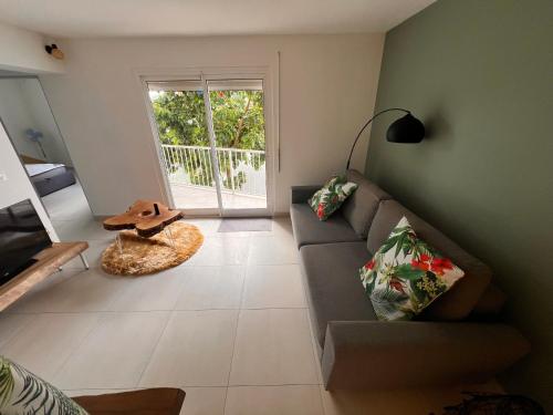 a living room with a couch and a window at La Perle Azurée in Noumea