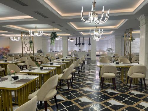 a dining room with tables and chairs and chandeliers at Canh Hung Palace in Hai Phong