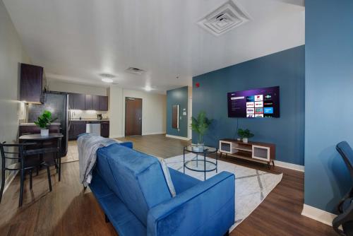 a living room with a blue couch and a kitchen at 1B1B Upscale Charm Valet Gym Lounge Roku in Pittsburgh