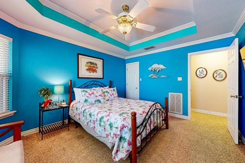 a blue bedroom with a bed and a ceiling fan at Sunset Cove in Bridgeport
