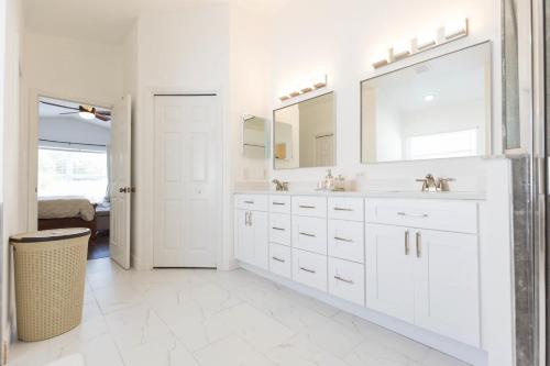 - une salle de bains blanche avec deux lavabos et un miroir dans l'établissement In the Middle of Paradise, à Riverview