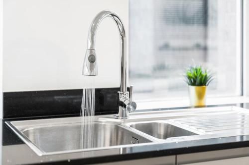 a kitchen sink with a faucet and a window at New 3 Bed Duplex/ City Centre in Birmingham