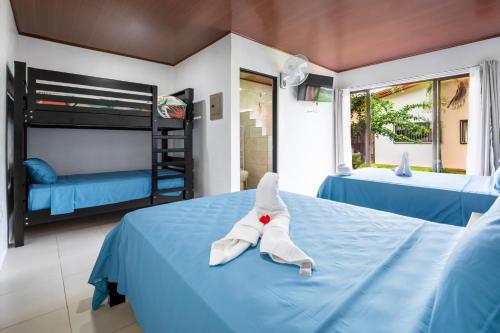 a bedroom with two beds and a bunk bed at Rio Celeste, comodidad, Aire Acondicionado in Upala