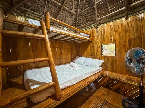 Letto a castello in una camera in legno con ventilatore. di EL BOSQUE RESORT CORON a Coron