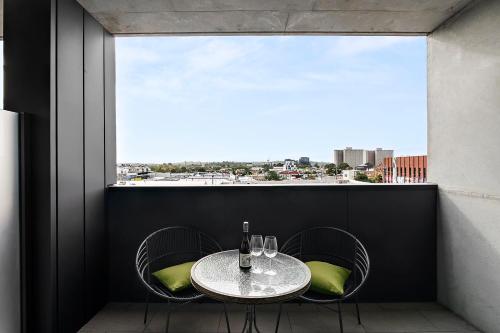 d'une table et de chaises sur un balcon avec une fenêtre. dans l'établissement Modern, Industrial Hideaway, à Melbourne
