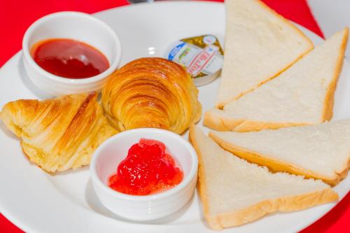 a white plate of food with bread and jam and butter at Angkor Tempora Boutique in Siem Reap