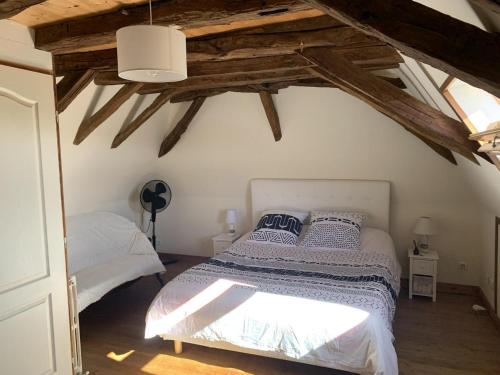 une chambre avec deux lits dans une pièce avec des plafonds en bois dans l'établissement Maison spacieuse avec piscine privée en Périgord, idéale pour familles et visites culturelles - FR-1-616-355, à Pézuls