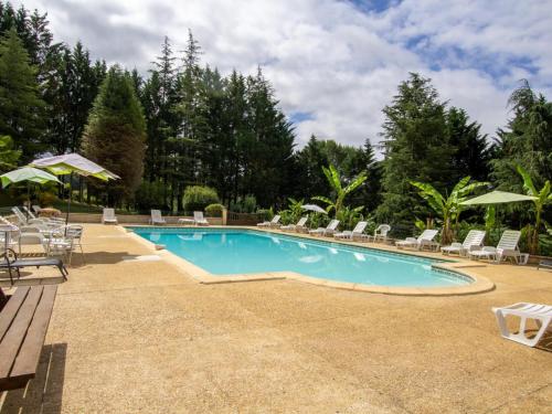 une piscine avec chaises et parasols dans l'établissement Maison de charme avec piscine, au cœur de Prats du Périgord, idéale pour 4 pers. et animaux acceptés - FR-1-616-353, à Prats-du-Périgord