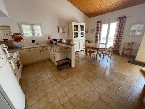 une cuisine et une salle à manger avec une table. dans l'établissement Maison familiale au cœur des pins avec jardin, proche plage, animaux acceptés, 700m de la côte. - FR-1-22-363, à La Tranche-sur-Mer