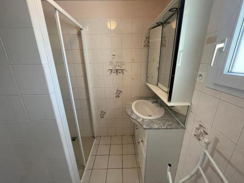 une petite salle de bain avec un lavabo et un miroir dans l'établissement Maison familiale au cœur des pins avec jardin, proche plage, animaux acceptés, 700m de la côte. - FR-1-22-363, à La Tranche-sur-Mer