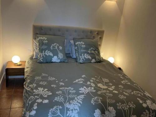 - un lit avec une couette et des oreillers bleus et blancs dans l'établissement Gîte cosy avec jacuzzi privé, jardin clos, et équipements modernes au cœur du Périgord pourpre - FR-1-616-363, à Saint-Aubin-de-Lanquais