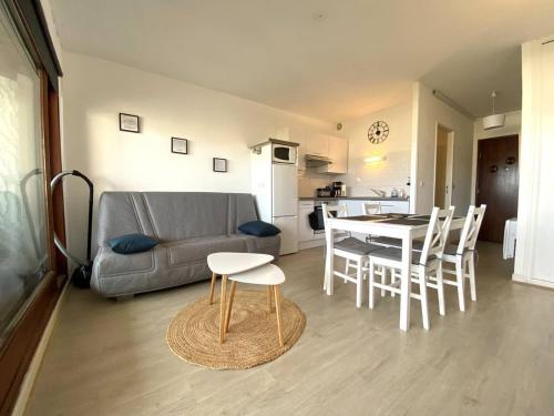 een woonkamer met een bank en een tafel en stoelen bij Appartement Perros-Guirec, 1 pièce, 2 personnes - FR-1-368-412 in Perros-Guirec