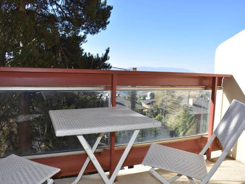 une table de pique-nique et deux chaises sur un balcon dans l'établissement Studio lumineux avec balcon, proche centre, garage et tout confort à Font-Romeu - FR-1-580-110, à Font-Romeu-Odeillo-Via