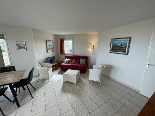 - un salon avec un canapé rouge et des fauteuils blancs dans l'établissement T3 6 pers avec piscine et accès direct plage - Saint-Cyprien - FR-1-106-101, à Saint-Cyprien