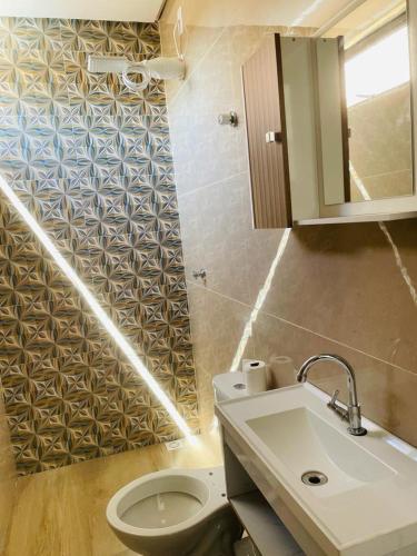 a bathroom with a toilet and a sink at Casa piscina 3 quartos in Goiânia