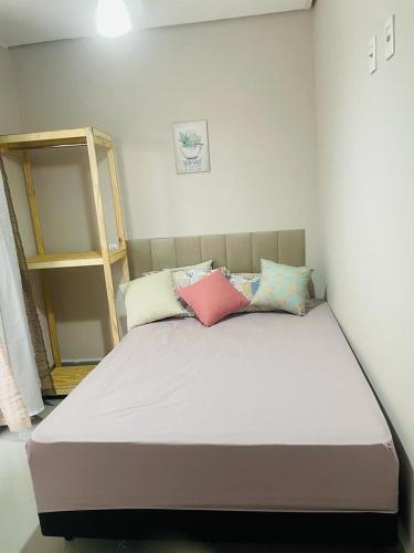 a bed with pillows on it in a room at Casa piscina 3 quartos in Goiânia