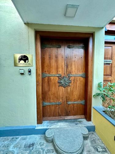 a large wooden door on a building with a sto at Colonial Retreat Villa in Talawatugoda